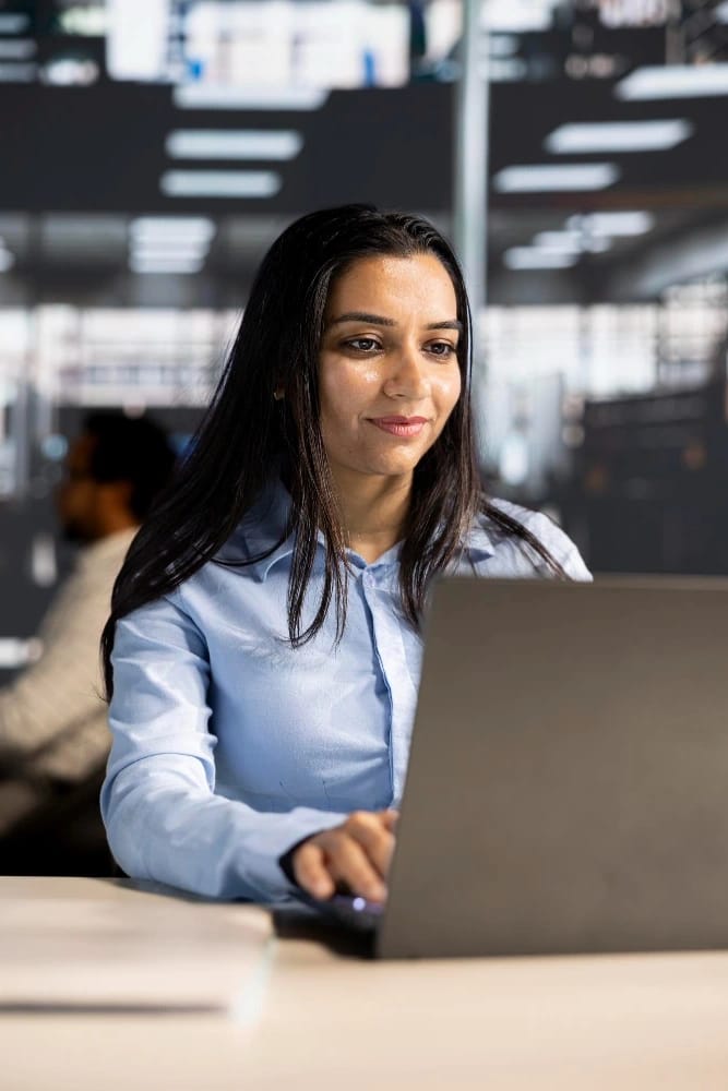 IT professional working on a laptop in a modern office